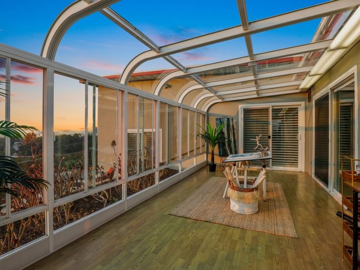 the inside of a house with wooden floors and glass walls