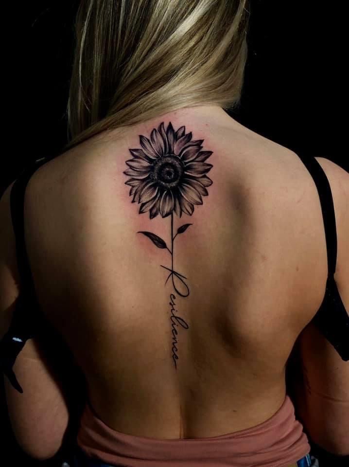 a woman with a sunflower tattoo on her back