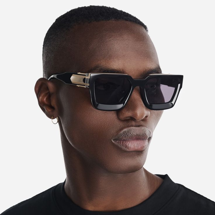 Elevate your style with our Baller sunglasses. These shades, in bold black with gold detailing, a GC logo, and unique Guilloché pattern sides, make a statement that reflects your individuality and unmatched confidence. Step out in sophistication and leave a lasting impression. MATERIAL Pure black Acetate frame with gold metal detailing UV 100% UVA/UVB Protection WEIGHT 70 g SIZE 56 □ 20 - 145 INCLUDED IN THE BOX Lens cleaning cloth, soft leather case Modern Wayfarer Sunglasses For Parties, Modern Black Shield Sunglasses For Party, Modern Black Shield Sunglasses For Evening, Formal Black Shield Sunglasses With Tinted Lenses, Trendy Square Frame Shield Sunglasses For Formal, Black Wayfarer Sunglasses For Formal Occasions, Trendy Square Frame Shield Sunglasses For Formal Occasions, Trendy Formal Shield Sunglasses With Square Frame, Black Sunglasses With Mirrored Lenses For Formal Occasions