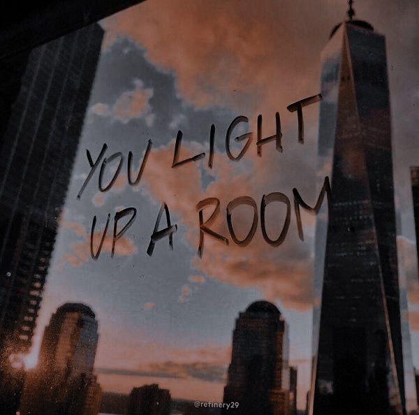 the words you light up a room are written in black ink on a glass window