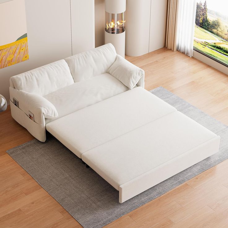 a white couch sitting on top of a hard wood floor next to a large window