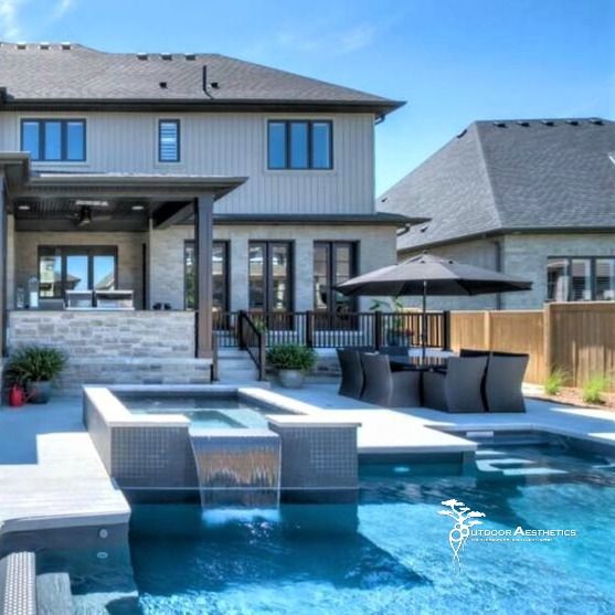 a large house with a pool in front of it and an umbrella on the patio