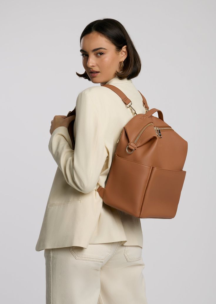 Stevie Midi is gender-neutral, edgy, and has the space to hold just the essentials. From a hike to the store, from work to the park, her eight internal pockets and easy-to-clean microfiber vegan leather make her the perfect bag to take just about anywhere. This ‘just right size’ is ideal for the mama who’s ready to downsize, and who likes nice things yet doesn’t want to fear the rough & tumble. Stevie’s all about options – her backpack converts to a shoulder strap, and her intuitive internal organization encourages minimalist-yet-prepared packing. Wear her as you please, pack her with ease. Ideal for newborn or essentialist packing. Common Uses: Diaper Bag, Work Bag, Travel Bag, Everyday Backpack Commuting Softback Bag With Zipper Pocket, Modern Backpack With Large Capacity, Versatile Laptop Backpack With Zipper Pocket, Versatile Laptop Bag With Zipper Pocket For Commuting, Versatile Leather Satchel Backpack For Commuting, Versatile Backpack With Zipper Pocket, Modern Leather Backpack Diaper Bag, Modern Leather Diaper Bag Backpack, Commuting Bags With Zipper Pocket