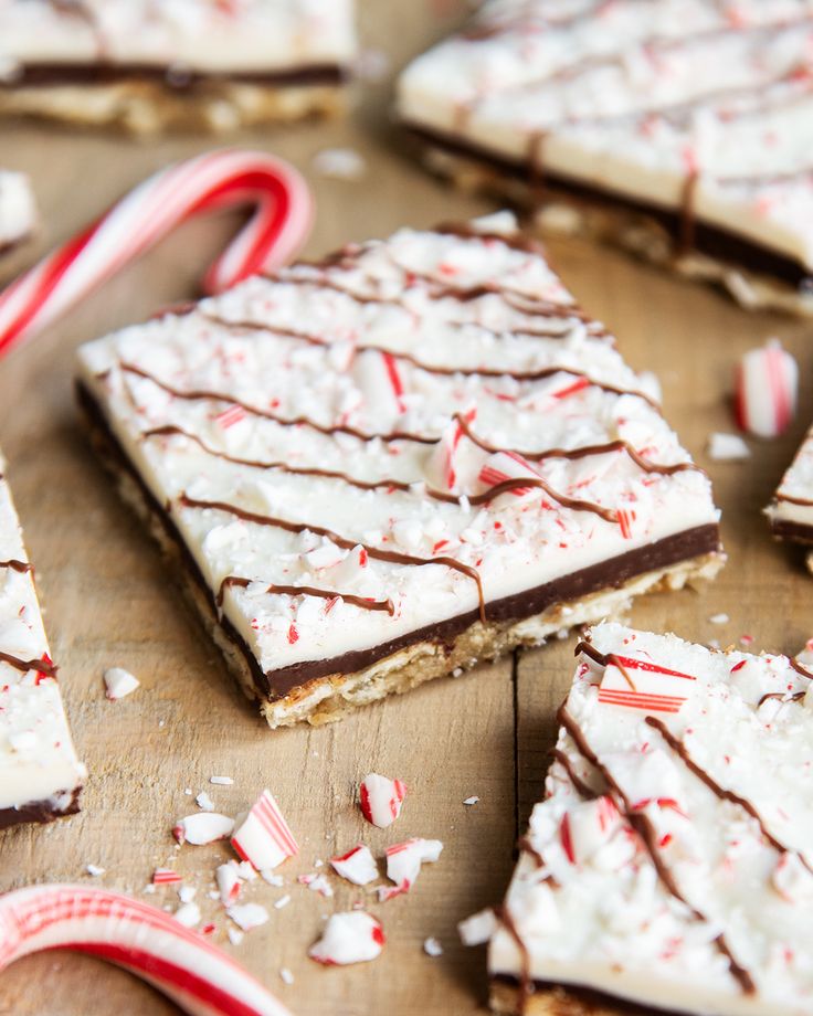 some candy canes and graham crackers on a wooden table with white frosting