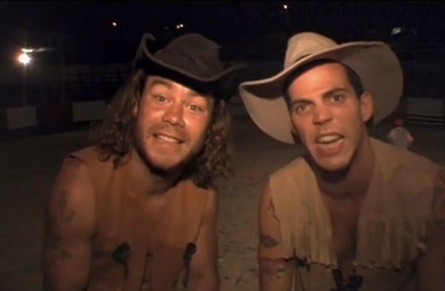 two men in cowboy hats posing for the camera