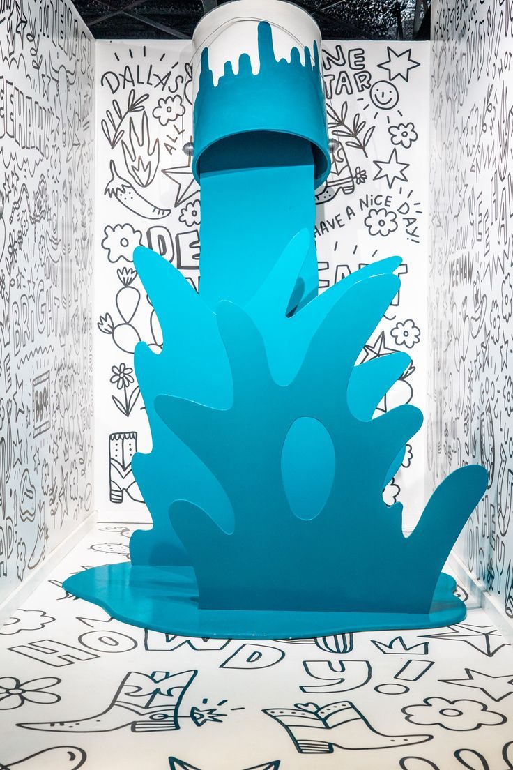 a blue water fountain sitting in the middle of a room with graffiti all over it