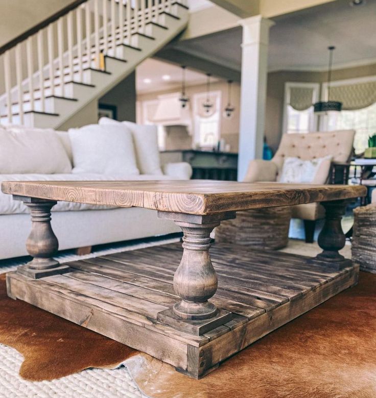 a living room with a couch, coffee table and stair case in the center area