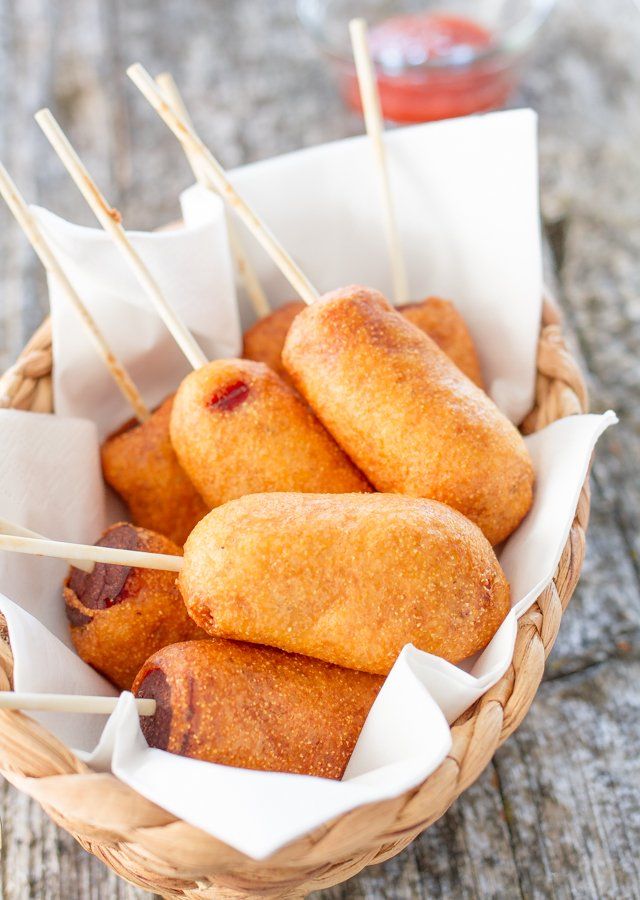 mini corn dogs in a basket with toothpicks