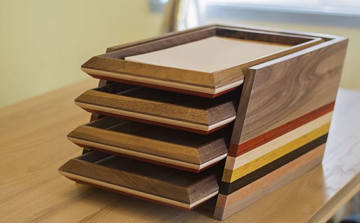 a stack of wooden trays sitting on top of a table