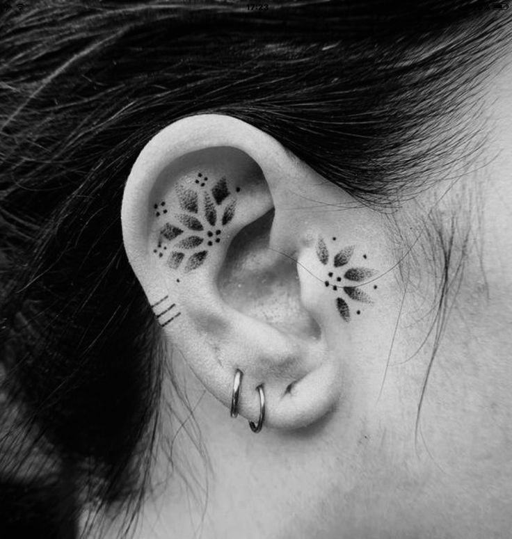 a woman's ear with black and white designs on it