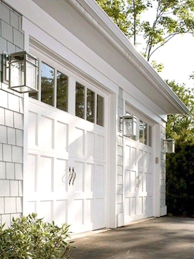 a white garage with two doors and windows