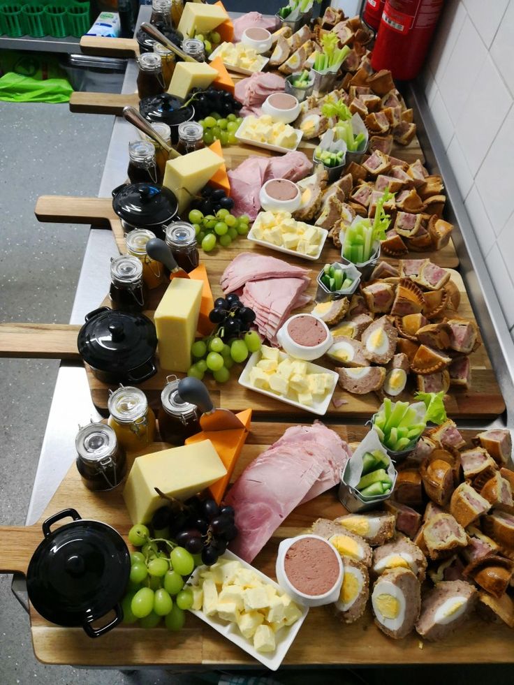 a long table filled with lots of different types of cheeses and other food items