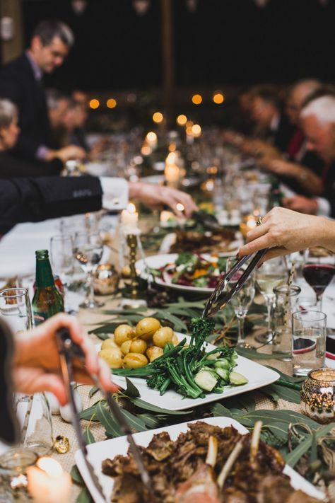 people sitting at a table with plates of food