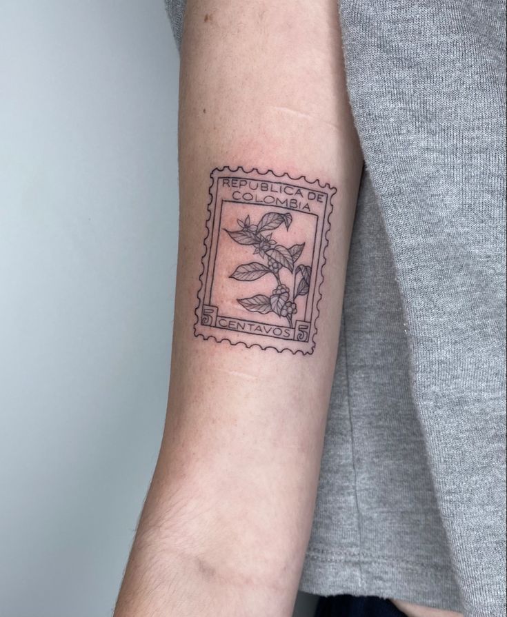 a woman's arm with a stamp on it that has a bird and flowers