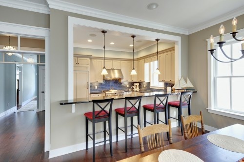 an open kitchen and dining room area with bar stools in front of the island