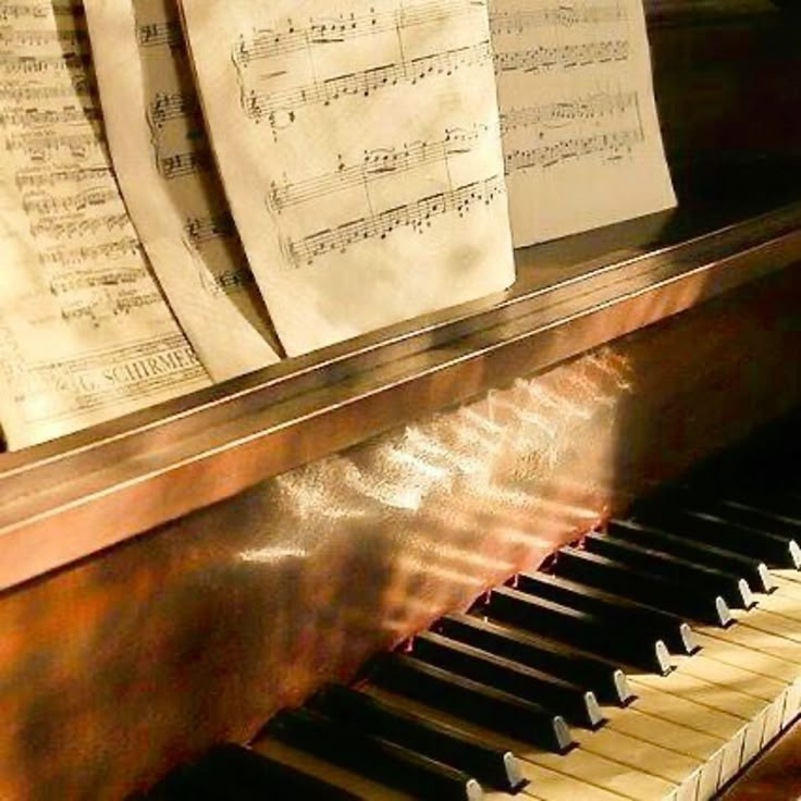 an old piano with sheet music on it's side and sheets of paper hanging from the top