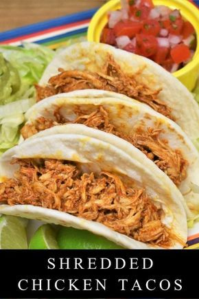 shredded chicken tacos on a plate with lettuce and tomatoes