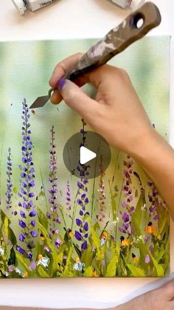 a person is painting flowers on a canvas