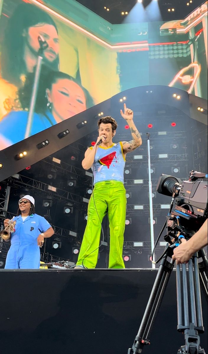 a man standing on top of a stage next to a camera