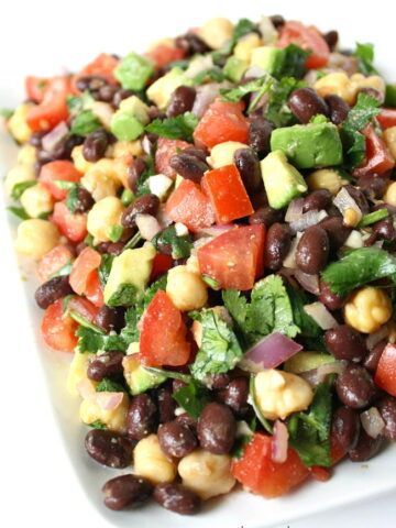 a white plate topped with black beans and veggies