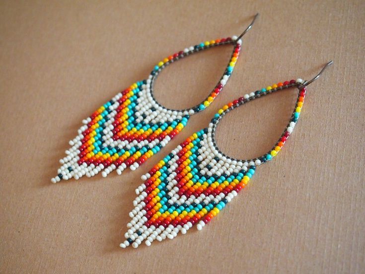 a pair of colorful beaded earrings sitting on top of a table