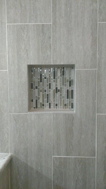 a white toilet sitting in a bathroom next to a tiled shower stall with a window