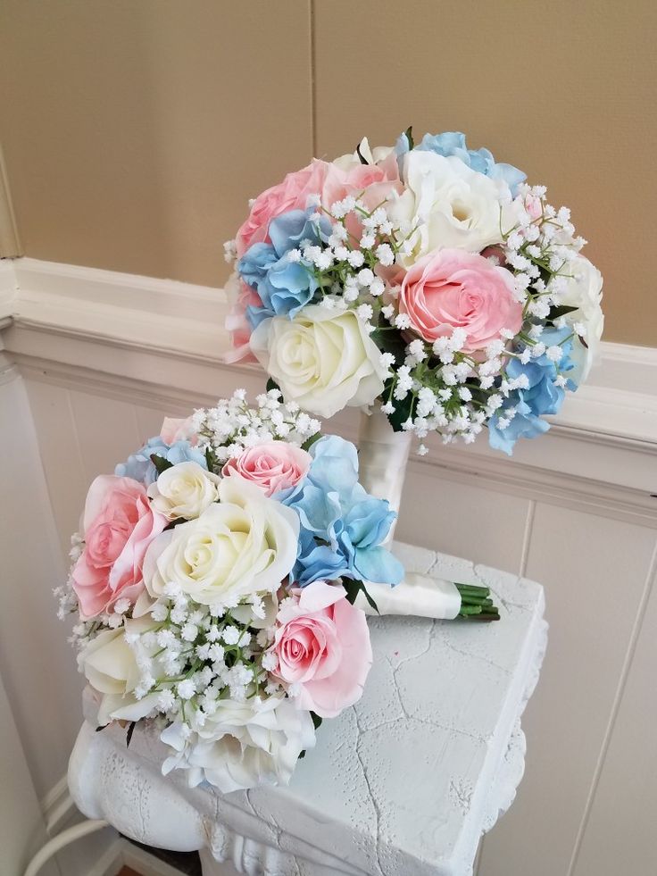 a bridal bouquet sitting on top of a white table next to a wall and window