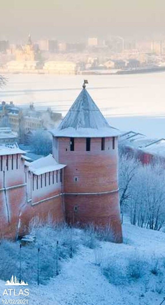 an old brick building in the middle of winter with snow on it's roof