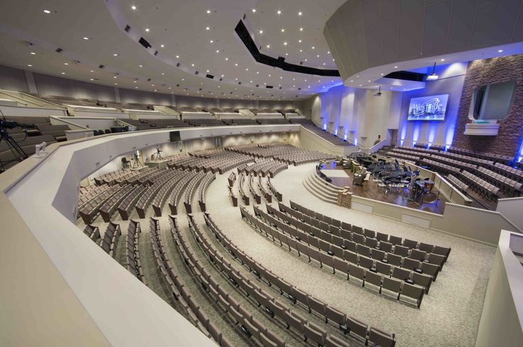 an empty concert hall with rows of seats and lights on the ceiling is pictured in this image