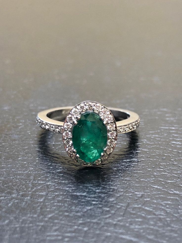 DeKara Designs Collection Our latest design! An elegant and lustrous Colombian Emerald surrounded by beautiful diamonds in a halo setting. Metal- 14K White Gold, .583. Stones- 1 Oval Colombian Emerald 1.25-1.40 Carats, 40 Round Diamonds, F-G color VS clarity, 0.30 carats. Latest of my creations. A beautiful Oval Colombian Emerald Halo Diamond Ring. The Emerald is a beautiful green and it is professionally prong set in between four double prongs. There are ten pave set round diamonds on each side Dazzling Formal Emerald Ring With Halo Design, Luxury Diamond Emerald Ring With Halo Design, Wedding Emerald Ring Brilliant Cut In 14k White Gold, Luxury Emerald Rings With Halo Detail, Dazzling Oval Emerald Ring In Platinum, Diamond White Brilliant Cut Emerald Ring, Brilliant Cut Emerald Ring In Diamond White, White Gold Brilliant Cut Emerald Wedding Ring, Elegant Oval Platinum Emerald Ring With Halo Setting