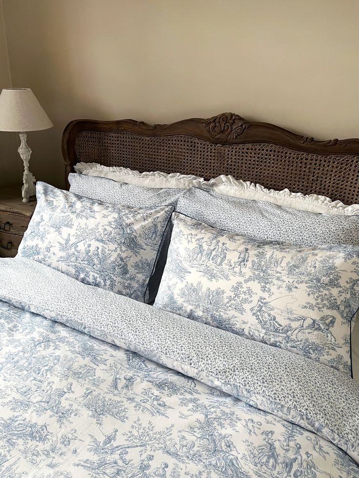 the bed is made with blue and white comforters, along with two lamps on either side