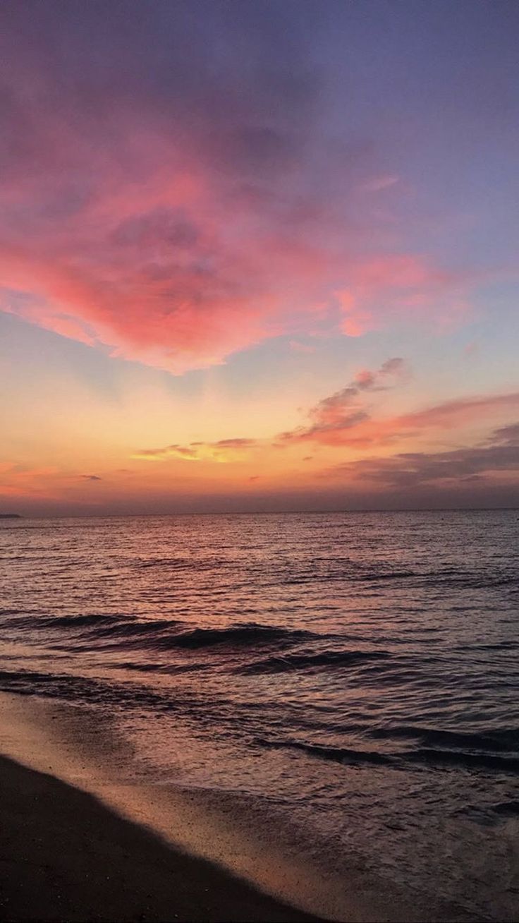 the sun is setting over the ocean and beach