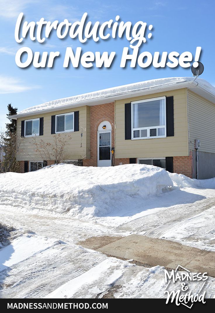 a house with snow piled on the front lawn and in front of it is a sign that reads, approaching our new house