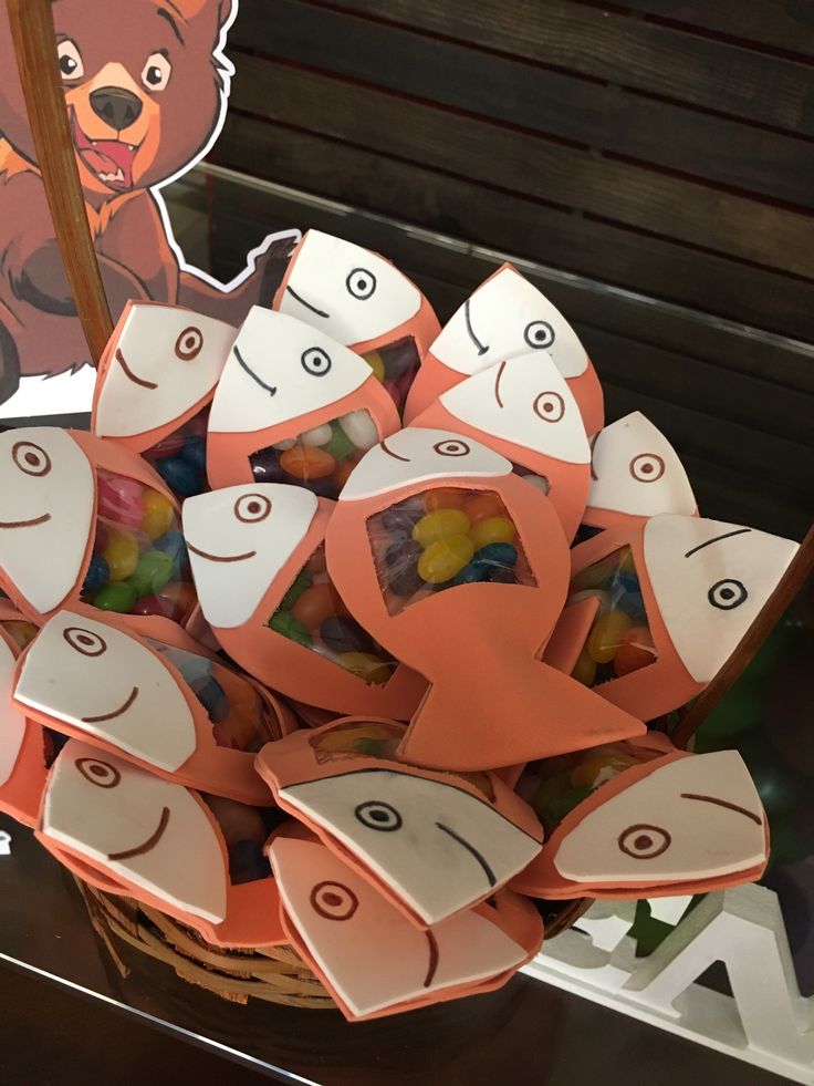 a basket filled with gummy bears sitting on top of a table next to a sign