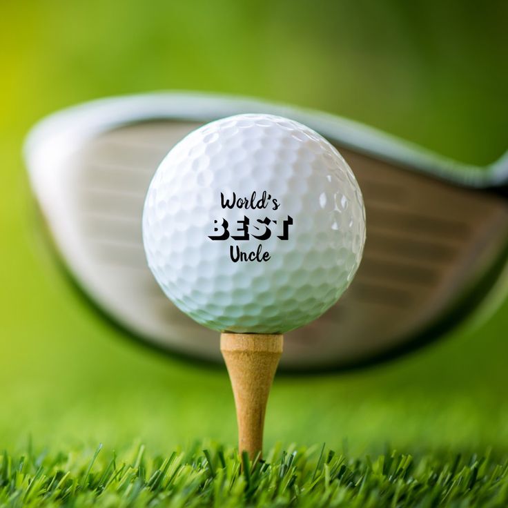 a golf ball sitting on top of a tee with the words world's best uncle written on it