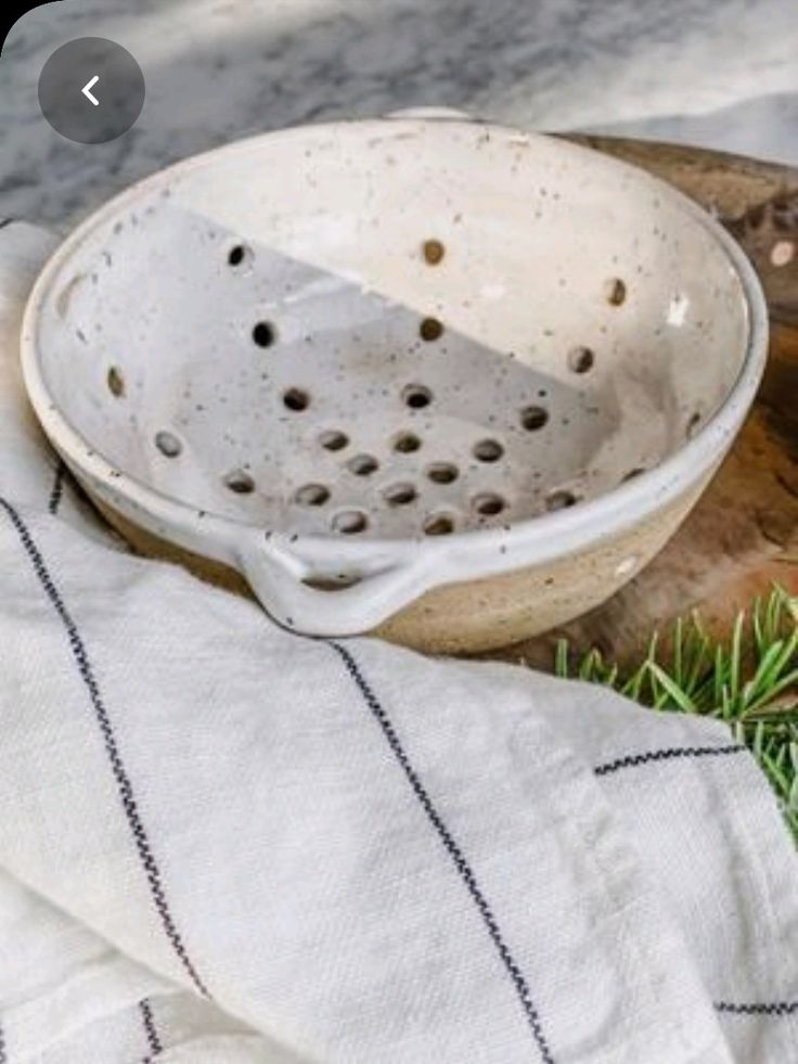 a white ceramic bowl sitting on top of a wooden cutting board next to a knife