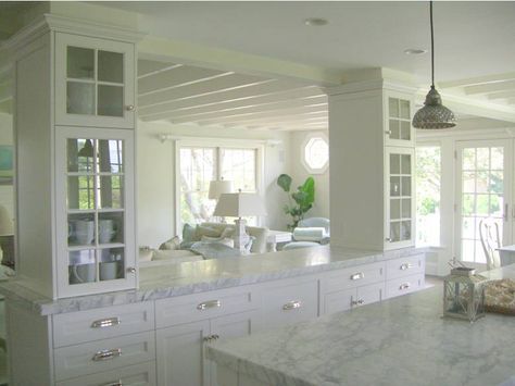 a large kitchen with white cabinets and marble counter tops