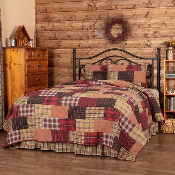 a bed room with a neatly made bed and a dresser next to the wooden wall