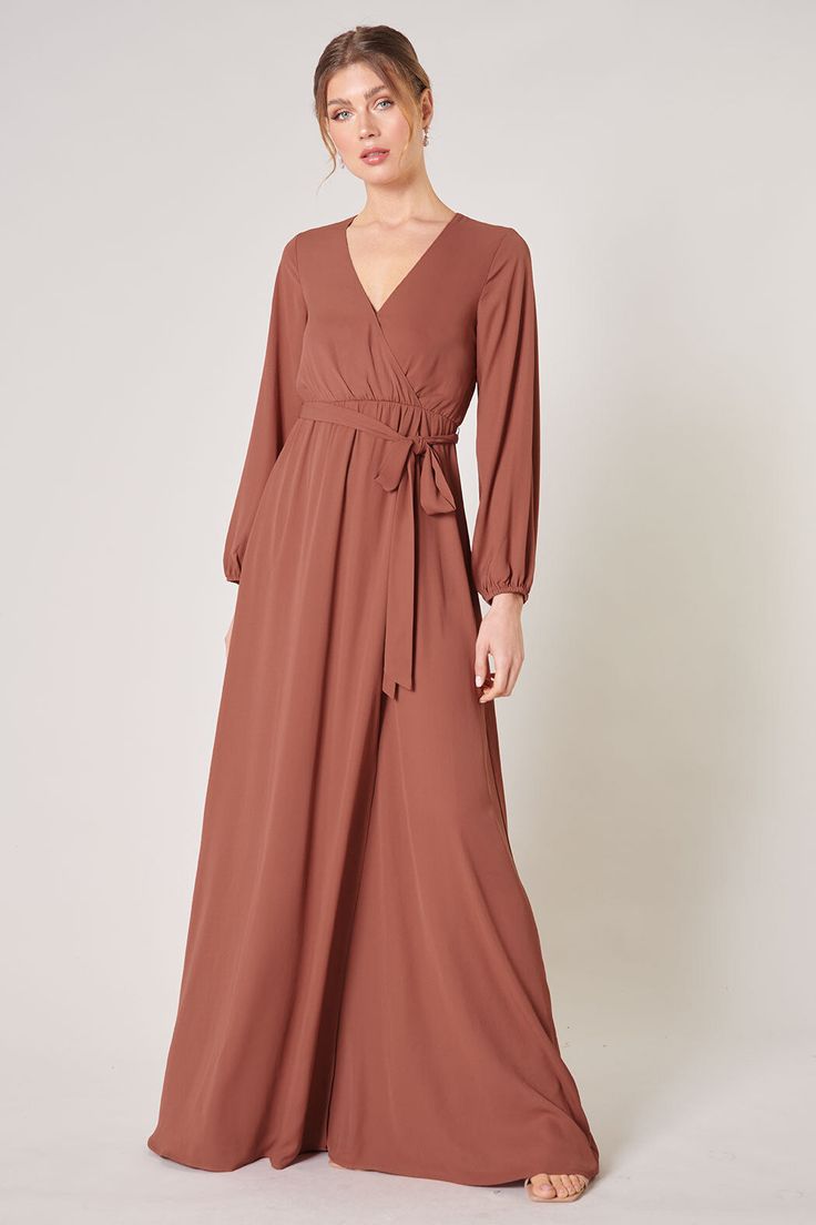 Warm and inviting, the Wholehearted Maxi Dress is a perfect combination of modest and sultry. Long balloon sleeves frame a surplice neckline separated by a tie at the waist, creating a forgiving faux wrap. The skirt maintains an airy and flowy shape that trails behind as you walk down the aisle. - Chiffon- Faux wrap- Keyhole- Elastic waist- Comes in 14 ColorsSize + Fit - Model is 5'9" and wearing size XS- Measurements taken from size S - Chest: 35"- Length: 63 1/4" Fabric Self: 100% PolyesterLin Fall V-neck Belted Maxi Dress, Belted V-neck Maxi Dress For Fall, Fall Belted V-neck Maxi Dress, Flowy Long Sleeve Belted Dresses, Flowy Long Sleeve Belted Maxi Dress, Long Sleeve Faux Wrap Evening Dress, Evening Long Sleeve Faux Wrap Dress, Solid Long Sleeve Wrap Dress For Formal Occasions, Fall Belted Maxi Dress For Date Night