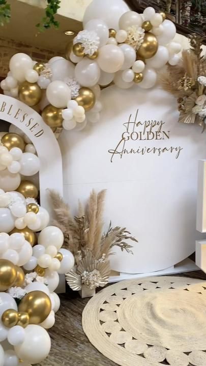 white and gold balloons are on display in front of a sign that says happy golden anniversary