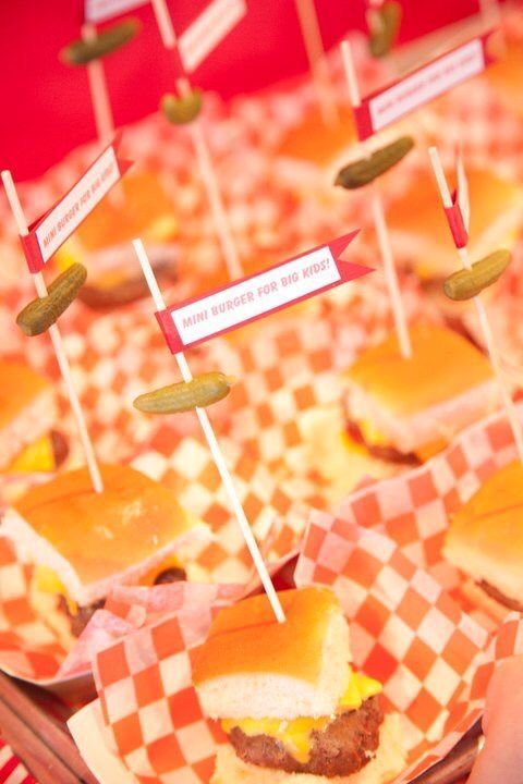 some food is sitting on top of checkered paper and sticks are sticking out of them