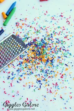 colorful confetti sprinkles and a grater on a white surface