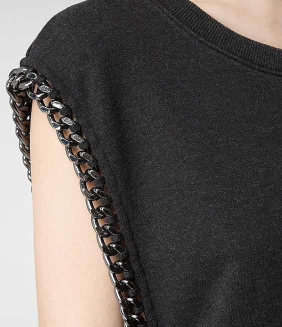 the back of a woman's black shirt with chains on it