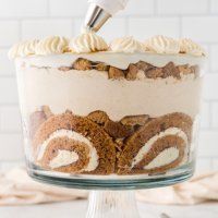 a cake with white frosting and swirls is being piped into the icing