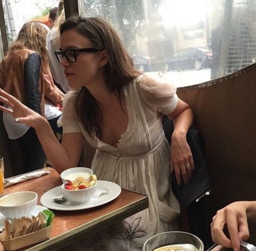 two women sitting at a table with plates of food and drinks in front of them