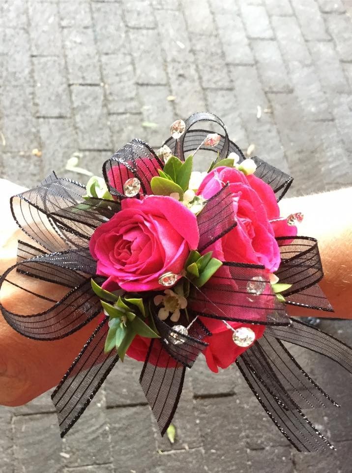 a wrist corsage with pink roses on it