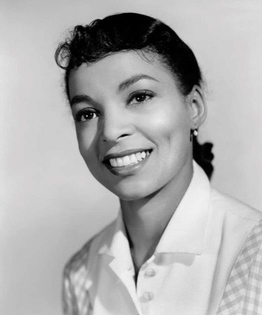 a black and white photo of a woman smiling