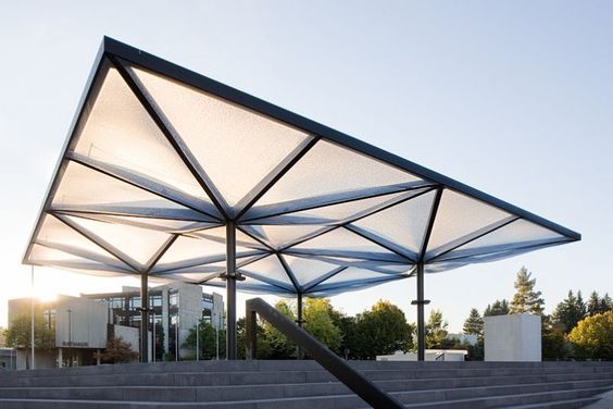 an outdoor area with concrete steps and a metal structure over it's entrance to the building