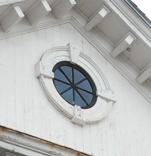 an old white building with a round window