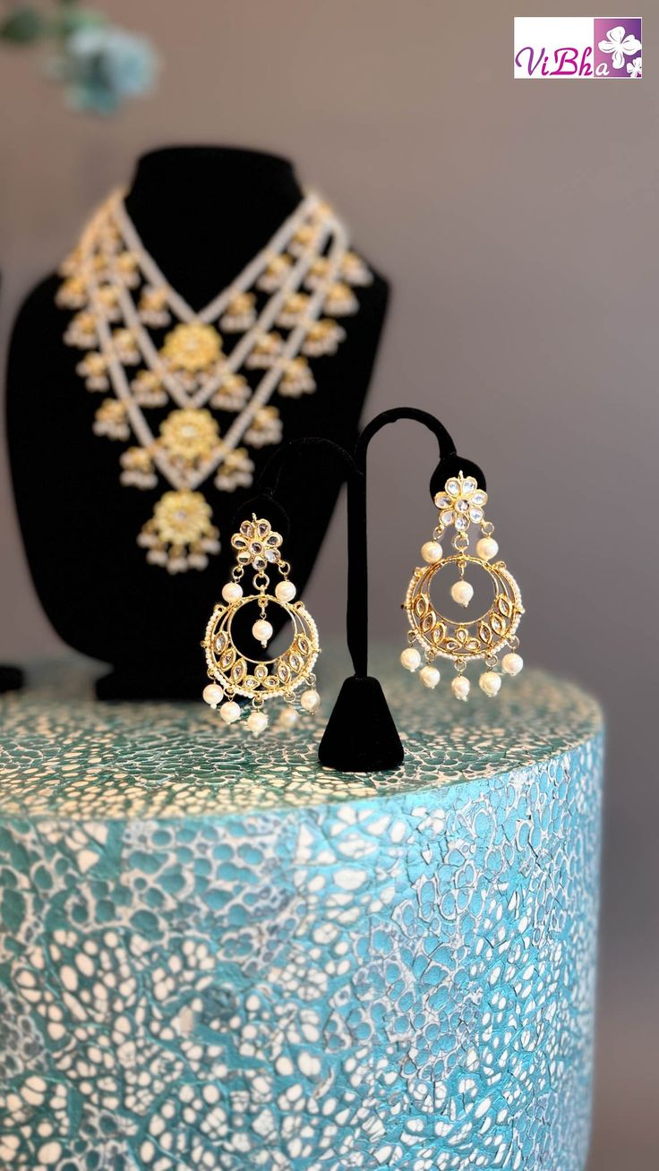 Indulge in luxury with our Pearl Kundan Polki Satlada Style set, complete with a stunning maang tikka and delicate chandbali earrings. Handcrafted with exquisite pearl and Kundan stones, this set exudes elegance and sophistication, making it a must-have for any special occasion. Elevate your look with this exclusive piece. Chandbali Chandelier Earrings With Intricate Design For Reception, Bollywood Style Chandelier Earrings With Intricate Design For Reception, Kundan Chandbalis Hand Set For Reception, Kundan Chandbalis With Hand Set Details For Reception, Hand Set Kundan Chandbalis For Receptions, Kundan Chandbalis For Reception With Hand Set, Kundan Chandbalis With Intricate Design For Reception, Chandbali Kundan Necklace For Eid Reception, Bollywood Chandbalis With Intricate Design For Festivals